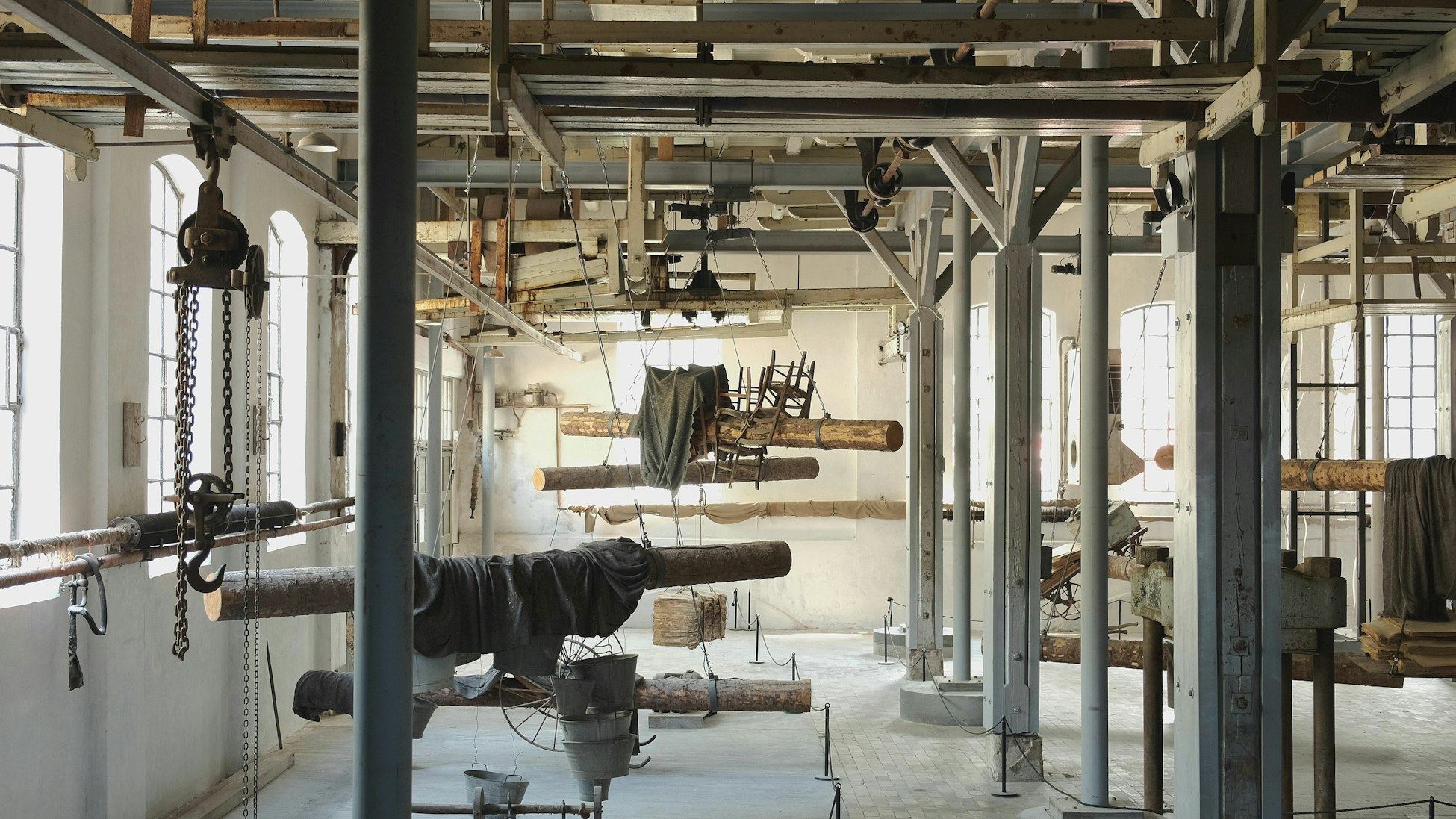 Bildet viser et gammelt fabrikkloakle som i dag er omgjort til et industrimuseum. Utsmykket med en installasjon som blant annet består av tømmerstokker og stoler.