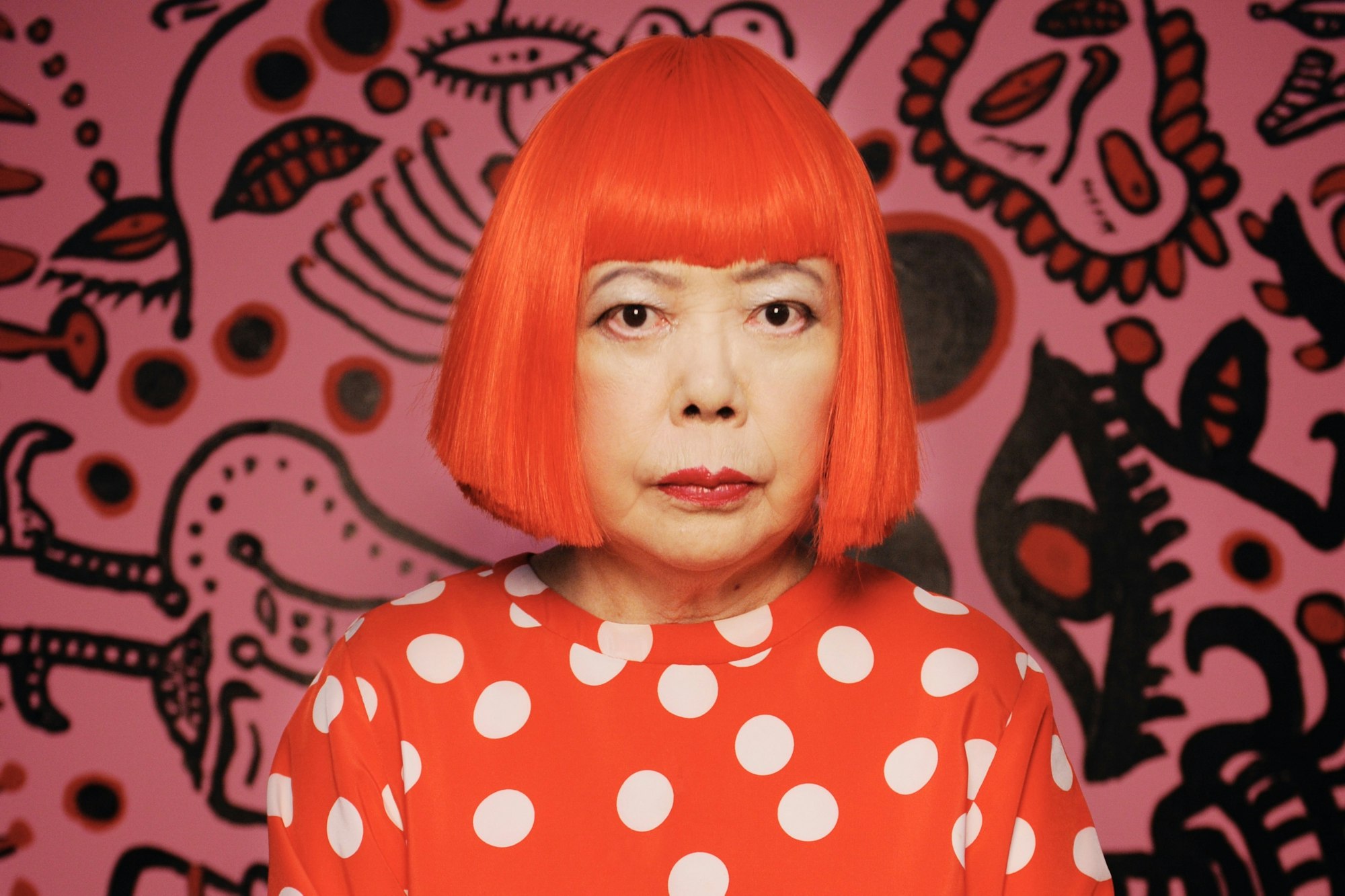 Portrett av kunstneren Yayoi Kusama. Rødt hår, bob og pannelugg.